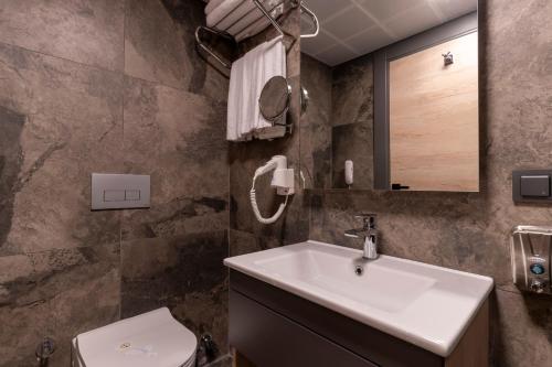 a bathroom with a sink and a toilet at IRENIC HOTEL in Antalya