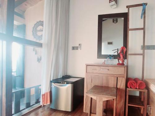 a bathroom with a vanity with a mirror and a trash can at Hakuna Matara Beach Bungalows in Matara