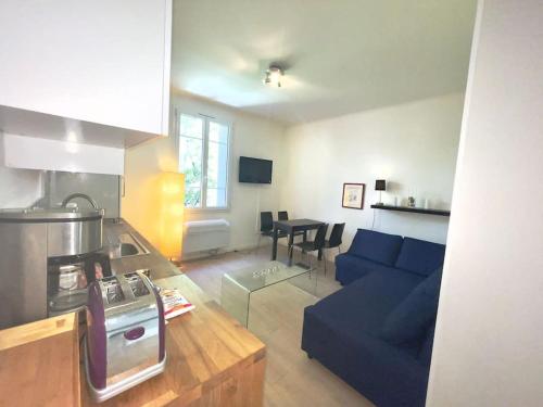 un salon avec un canapé bleu et une cuisine dans l'établissement Le Canada - 2Pièces Croisette plage derrière le Carlton calme, à Cannes