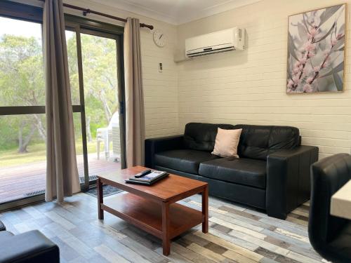 a living room with a couch and a coffee table at Emu Beach Chalets in Albany