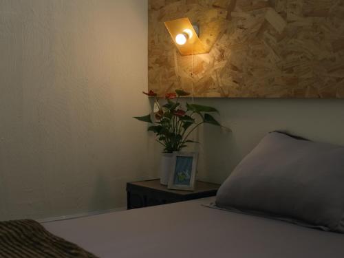 um quarto com uma cama com um candeeiro e uma planta em Vit-bau Room - Double Room 2 person - Duck Homestay Ben Tre em Ấp Phú Lợi
