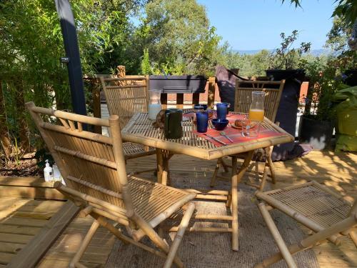 une table et des chaises en bois sur une terrasse dans l'établissement Saint tropez-Gassin Bungalow LUXE 6 personnes, à Gassin