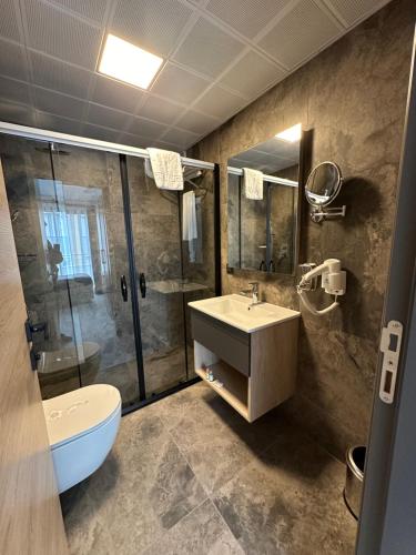 a bathroom with a sink and a shower and a toilet at IRENIC HOTEL in Antalya
