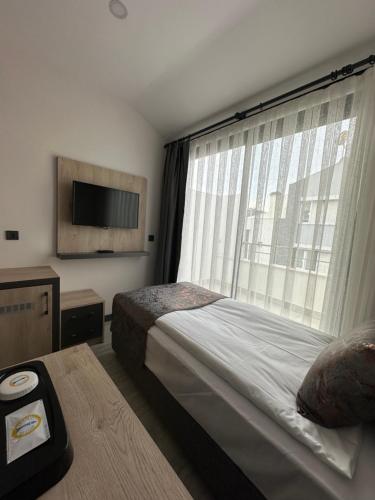 a bedroom with a bed and a large window at IRENIC HOTEL in Antalya