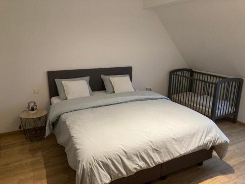 a bedroom with a large bed with a crib at EN PASSANT appartement in Diksmuide