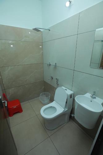 a bathroom with a white toilet and a sink at Premier Tourist Home in Kunnamkulam