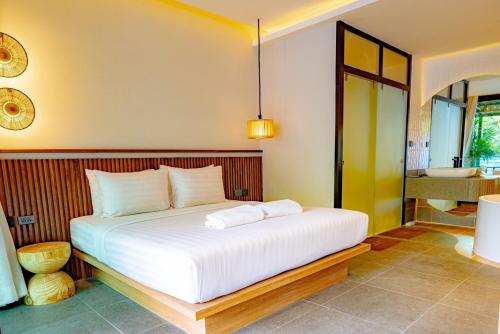 a bedroom with a large bed and a bathroom at Sangthian Beach Resort in Ko Samed