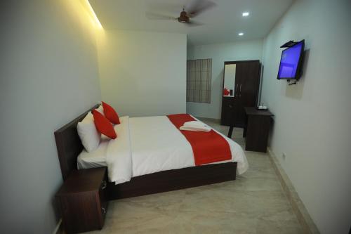 a bedroom with a bed and a television in it at Premier Tourist Home in Kunnamkulam