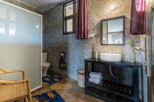 a bathroom with a sink and a mirror at Kinigi Cottage in Kinigi