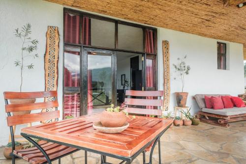 a wooden table and chairs in a living room at Kinigi Cottage in Kinigi