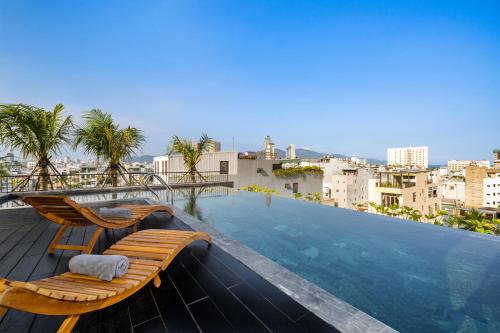 a swimming pool with a chaise lounge on the roof of a building at Thè HEM Hotel and Apartment in Da Nang