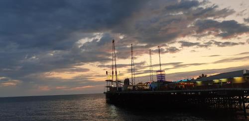 ブラックプールにあるSouth Beach Kings Promenade Hotelの夕日の見える桟橋に停泊する巡航船