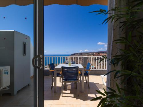 a table and chairs on a balcony with a view of the ocean at Incredible Sunsets in Puerto Rico de Gran Canaria