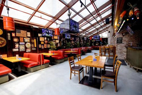 a restaurant with wooden tables and red chairs at DoubleTree by Hilton Doha Old Town in Doha