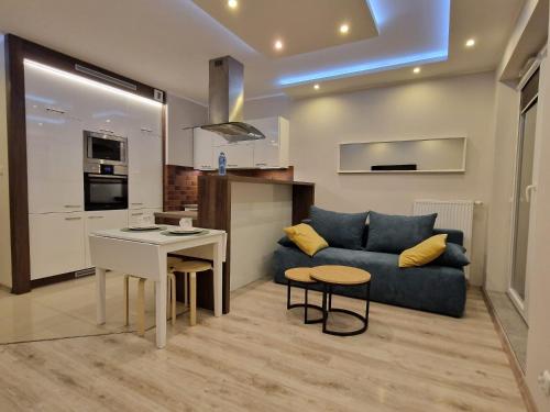 利阿達的住宿－Apartament morski Aquasfera，客厅配有蓝色的沙发和桌子