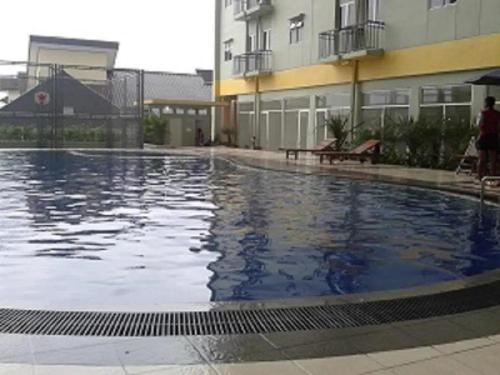 einem großen Pool vor einem Gebäude in der Unterkunft Metro Suits Apartment Bandung in Bandung
