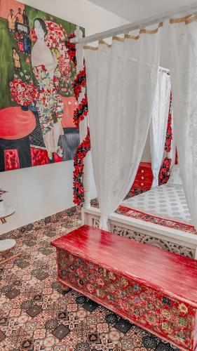 a room with a bed with a red bench at CHATEAU MADEIRA BY GOAN DIARIES in Moira