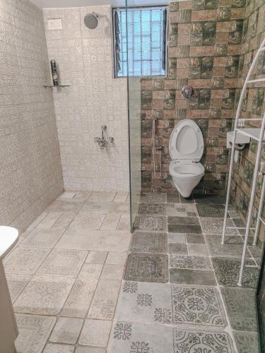 a bathroom with a toilet and a shower at CHATEAU MADEIRA BY GOAN DIARIES in Moira