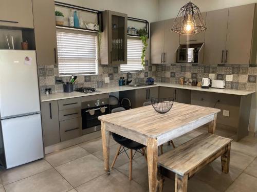 a kitchen with a wooden table and a refrigerator at The Lodge on Ilona in Tierpoort