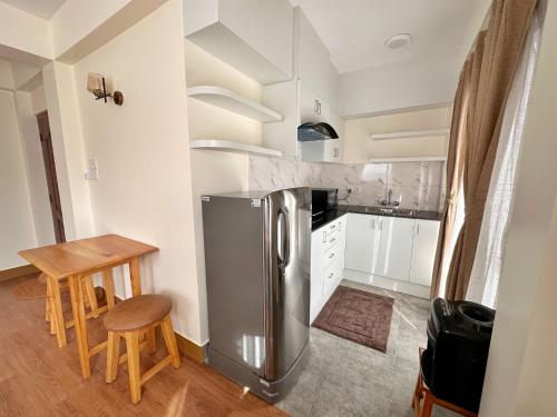 a kitchen with a stainless steel refrigerator and a table at Shakya House in Pātan