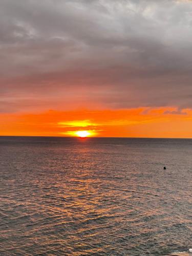 a sunset over the ocean with the sun setting at CasaDel Beach House in Mabini