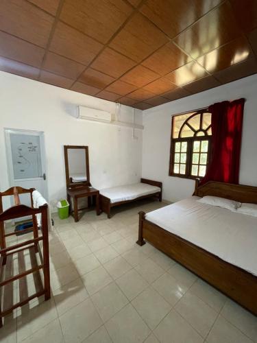 1 dormitorio con 1 cama, 1 silla y 1 ventana en Bhawana Canal View Resort, en Nochchiyagama