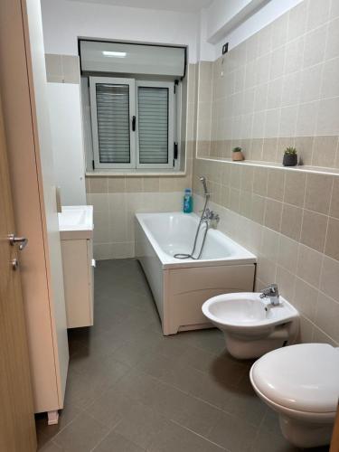 a bathroom with a tub and a toilet and a sink at Paulina Apartament in Timişoara