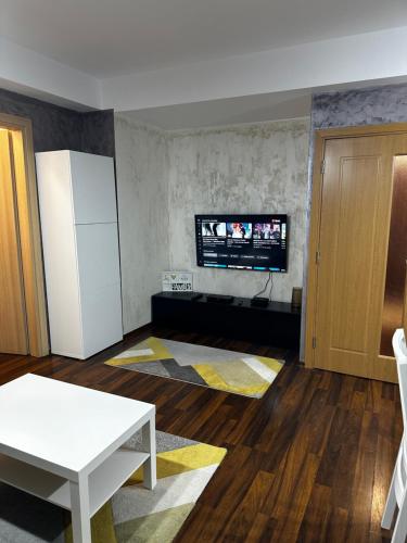 a living room with a white refrigerator and a tv at Paulina Apartament in Timişoara