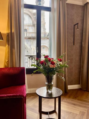 a vase of flowers on a table in front of a window at 286 Piazza San Marco - Relais il Doge in Venice