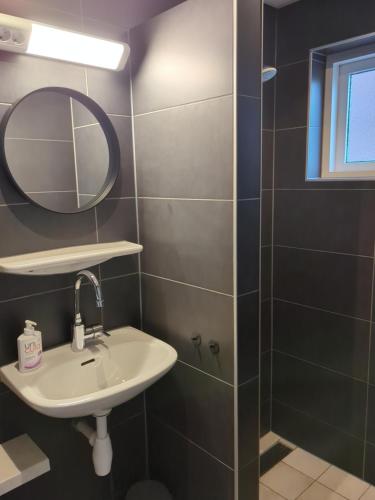 y baño con lavabo y espejo. en Hotel-Pension Ouddorp en Ouddorp