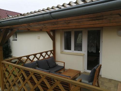 a wooden deck with two chairs and a house at Apartmány U Krumlova in Český Krumlov