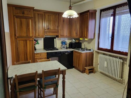 eine Küche mit Holzschränken und einem Tisch mit Stühlen in der Unterkunft Villa Zene in Montù Beccaria