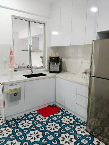 a kitchen with white cabinets and a red rug on the floor at Rawang Conner lot homestay in Rawang