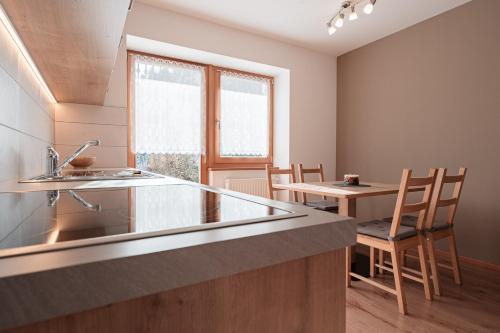 a kitchen with a sink and a table with chairs at Lüch da Morgnun in San Vigilio Di Marebbe