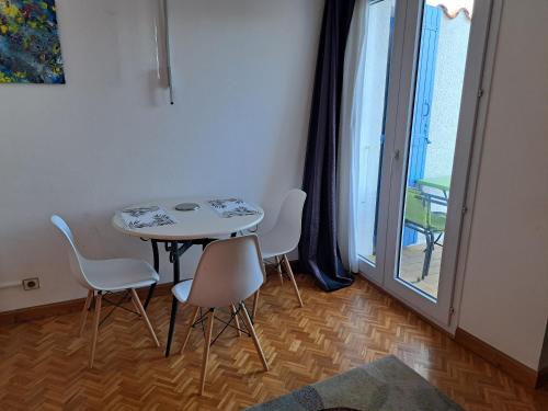 une table et des chaises dans une pièce avec une fenêtre dans l'établissement La Cancane, à Elne