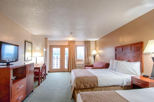 a hotel room with two beds and a flat screen tv at Park Tower Inn in Pigeon Forge