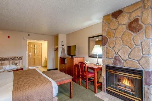 a hotel room with a fireplace in a bedroom at Park Tower Inn in Pigeon Forge