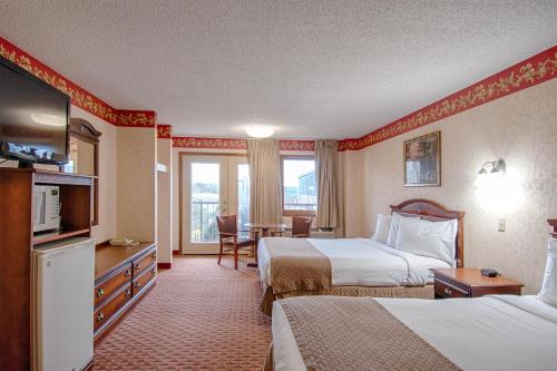 a hotel room with two beds and a television at Park Tower Inn in Pigeon Forge