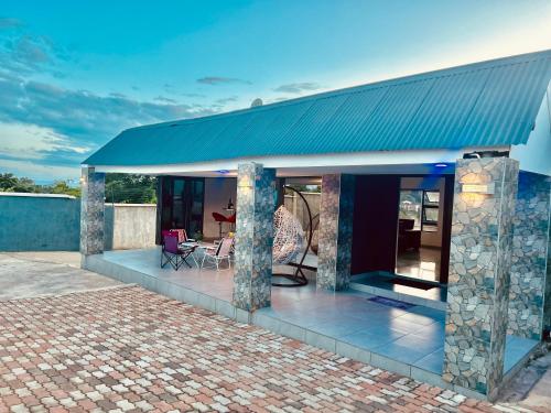 a house with a blue roof with a patio at Skyfly Bed & Breakfast in Manzini