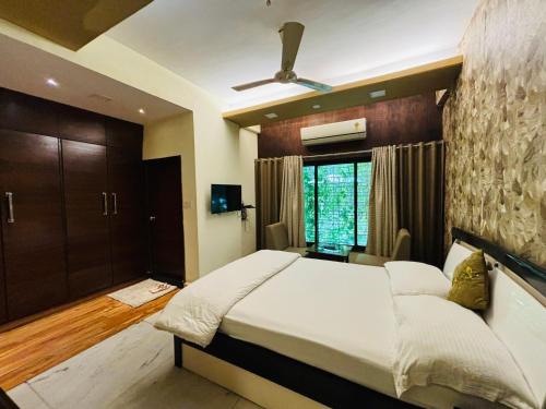 a bedroom with a large bed and a window at Royal Palms Luxury Service Apartment in Nagpur
