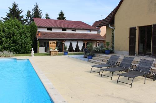 een patio met stoelen en een zwembad voor een huis bij Appartement Studio Agrita in Wittisheim