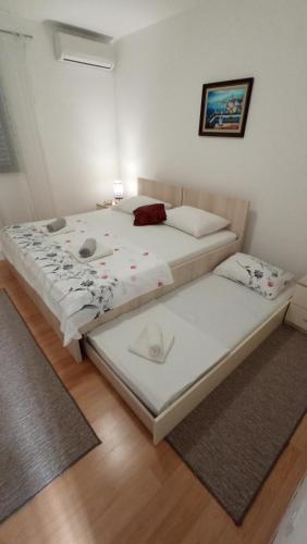 two twin beds in a room with wooden floors at Apartment Relax in Komolac
