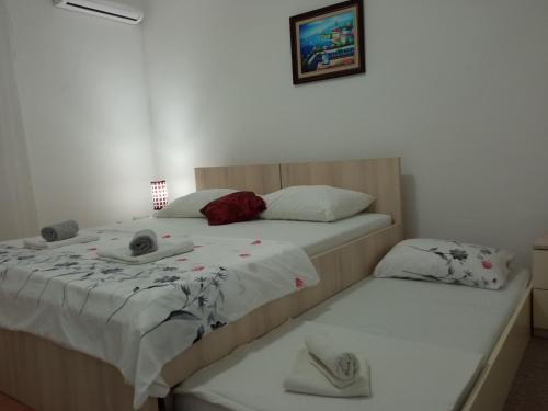 two beds in a room with towels on them at Apartment Relax in Mokošica