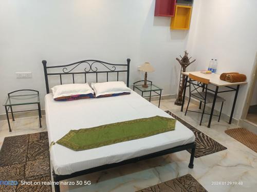 a bedroom with a bed and a table with chairs at The King's Castle in Guwahati