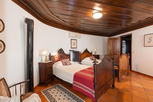 a bedroom with a bed and a wooden ceiling at Casa Da Avo Genoveva in Tomar