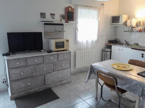 Il comprend une cuisine avec une commode et une télévision. dans l'établissement Grand studio sur jardin Nantes Beaujoire B, à Nantes