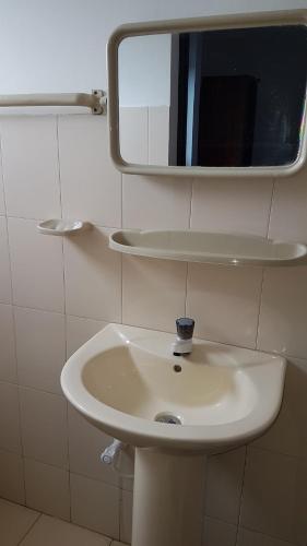 a white sink in a bathroom with a mirror at Geesh Residence : Rooms in Jaffna in Jaffna