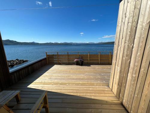 a wooden deck with a view of the water at Attme Have in Brostadbotn