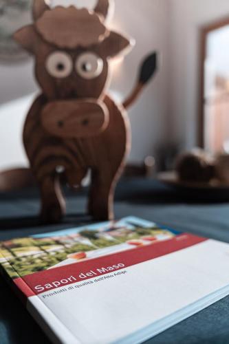 a book sitting on top of a table with a toy cow at Lüch da Morgnun in San Vigilio Di Marebbe