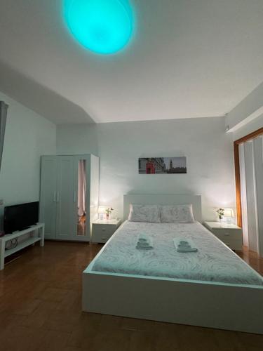 a white bedroom with a bed and a blue light at Guest House Demma in Rome